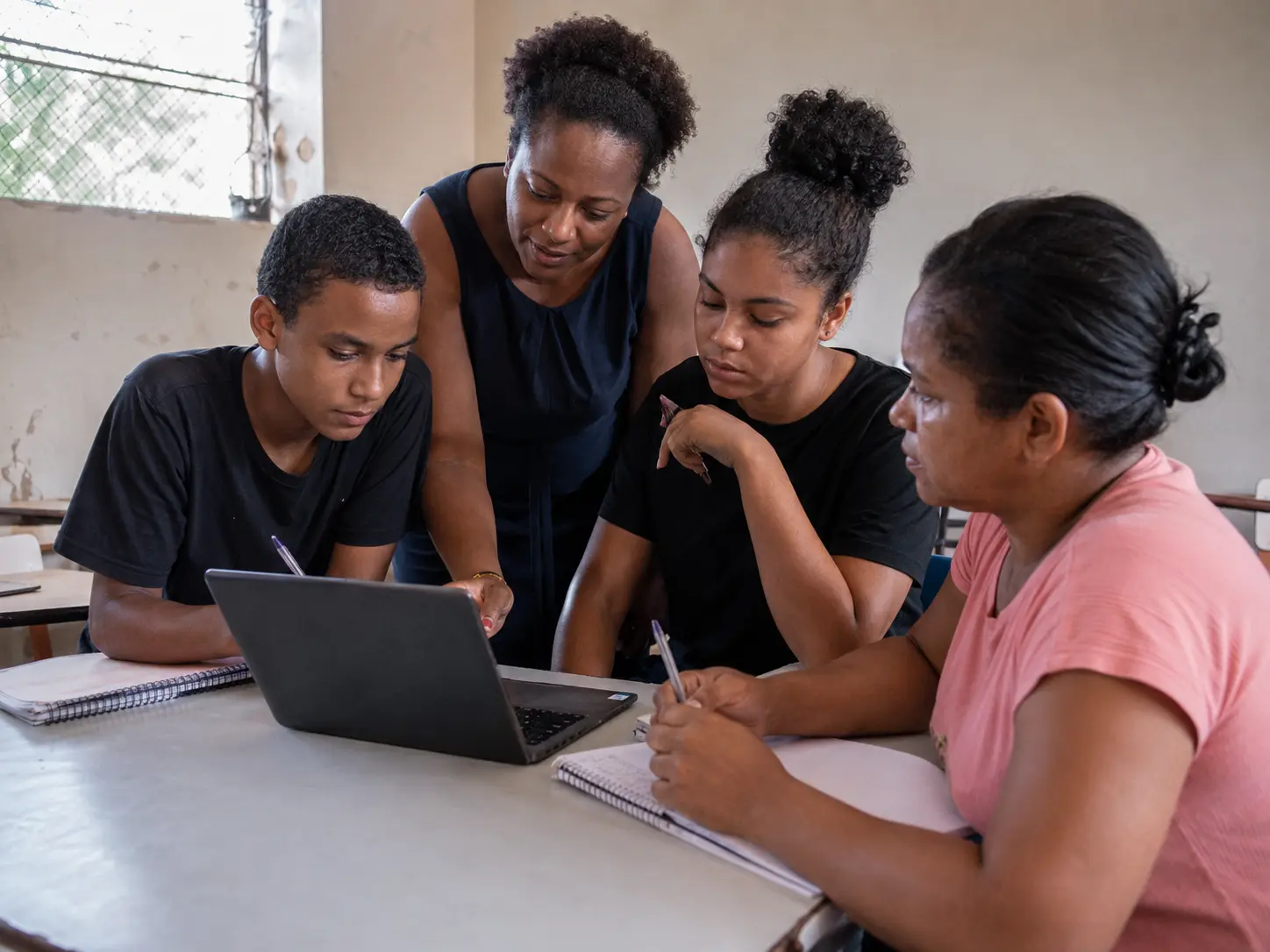 Educadora acompanha jovens em uma experiência de aprendizagem e tecnologia.