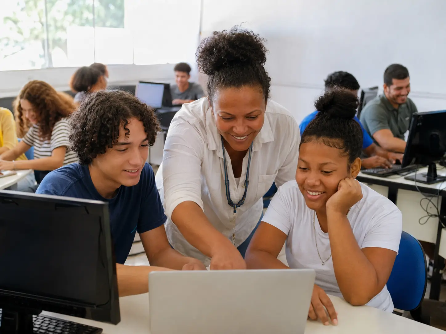 Educadora orienta jovens em uma experiência de aprendizagem e inclusão digital.